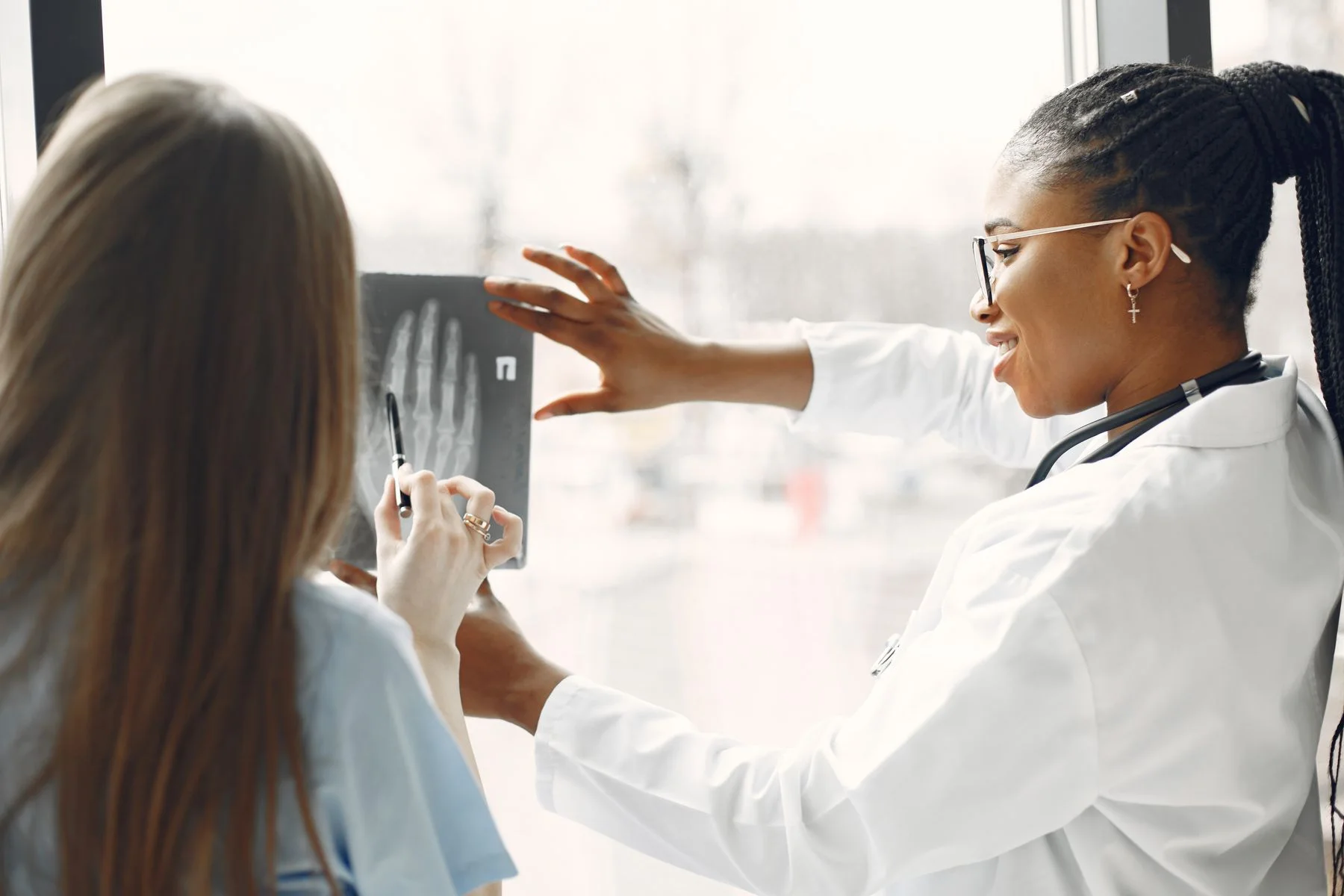 A clinician showing a patient an X-ray image during a consultation.