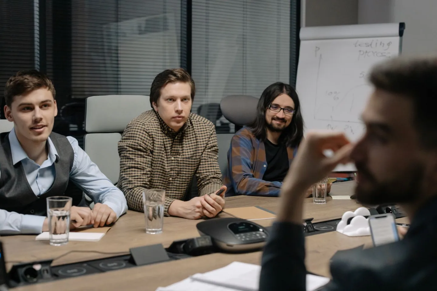 Colleagues listen during a meeting around a conference table.