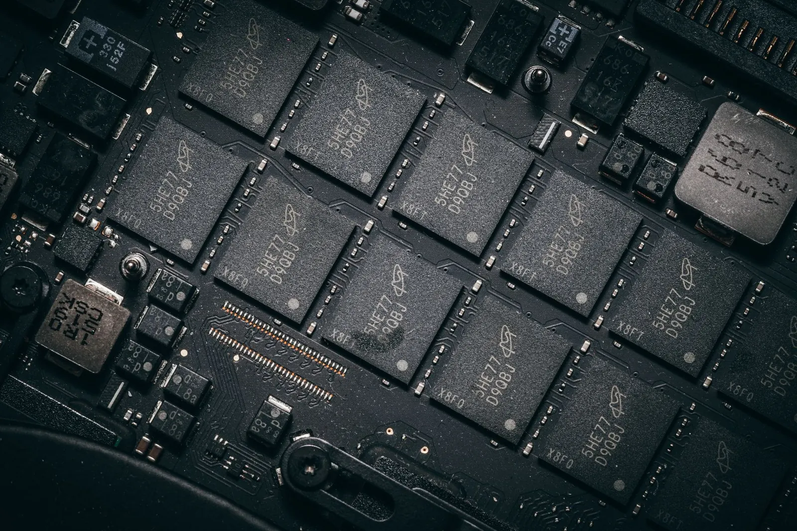 A close view of dark electronic components and chips on a computer circuit board.