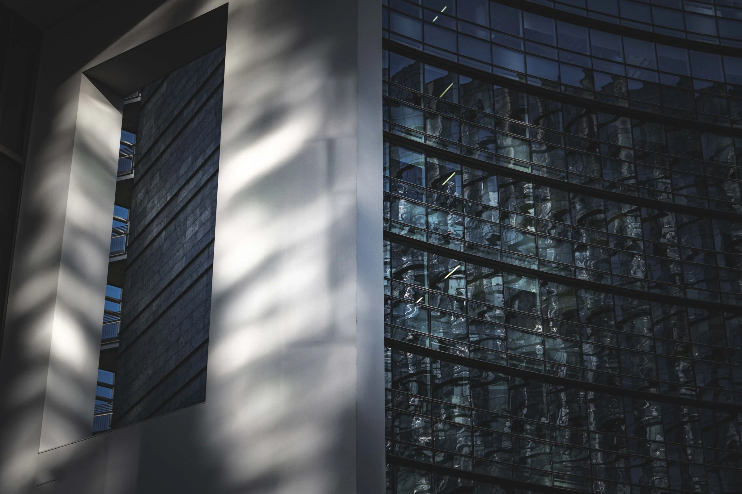 Faceted glass architecture reflecting the surrounding city.