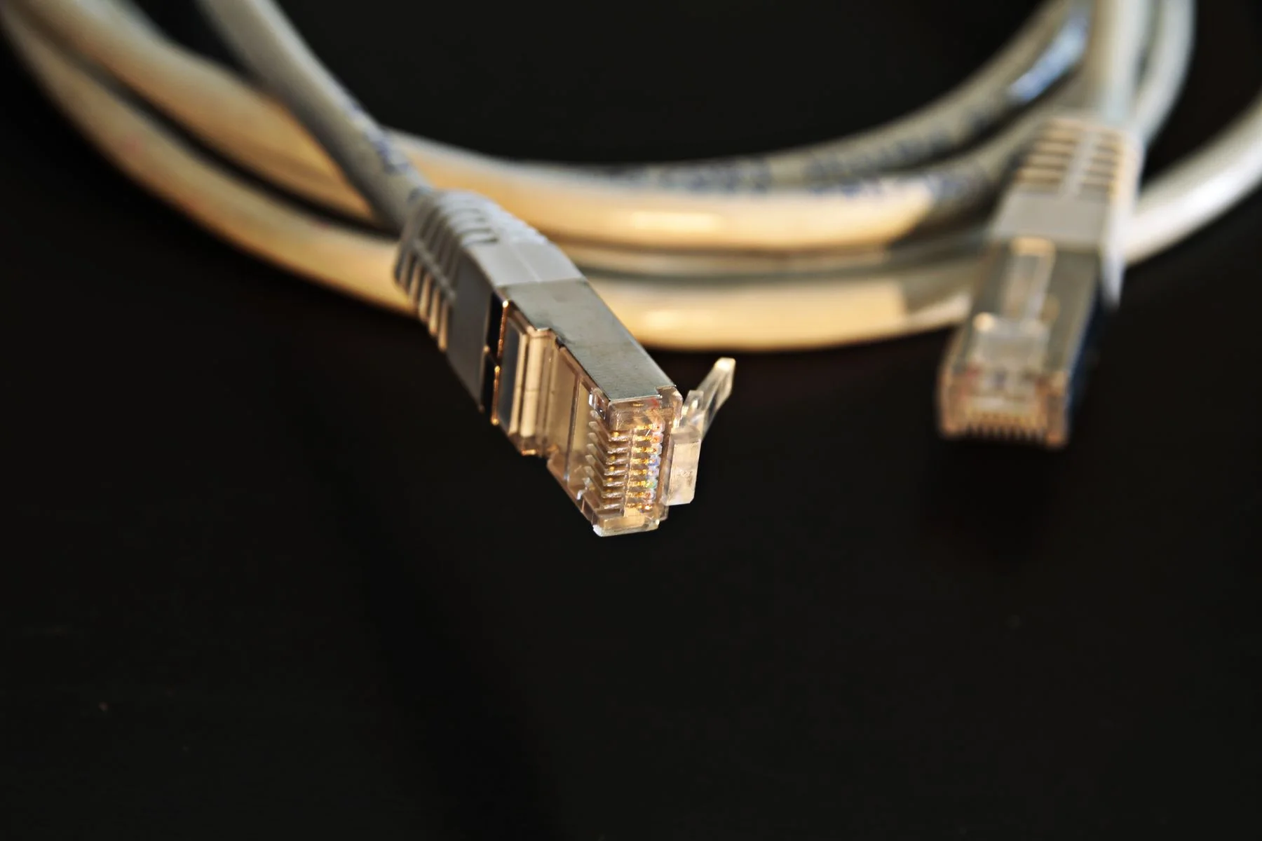 Ethernet connectors against a dark background, illustrating a connection between systems.