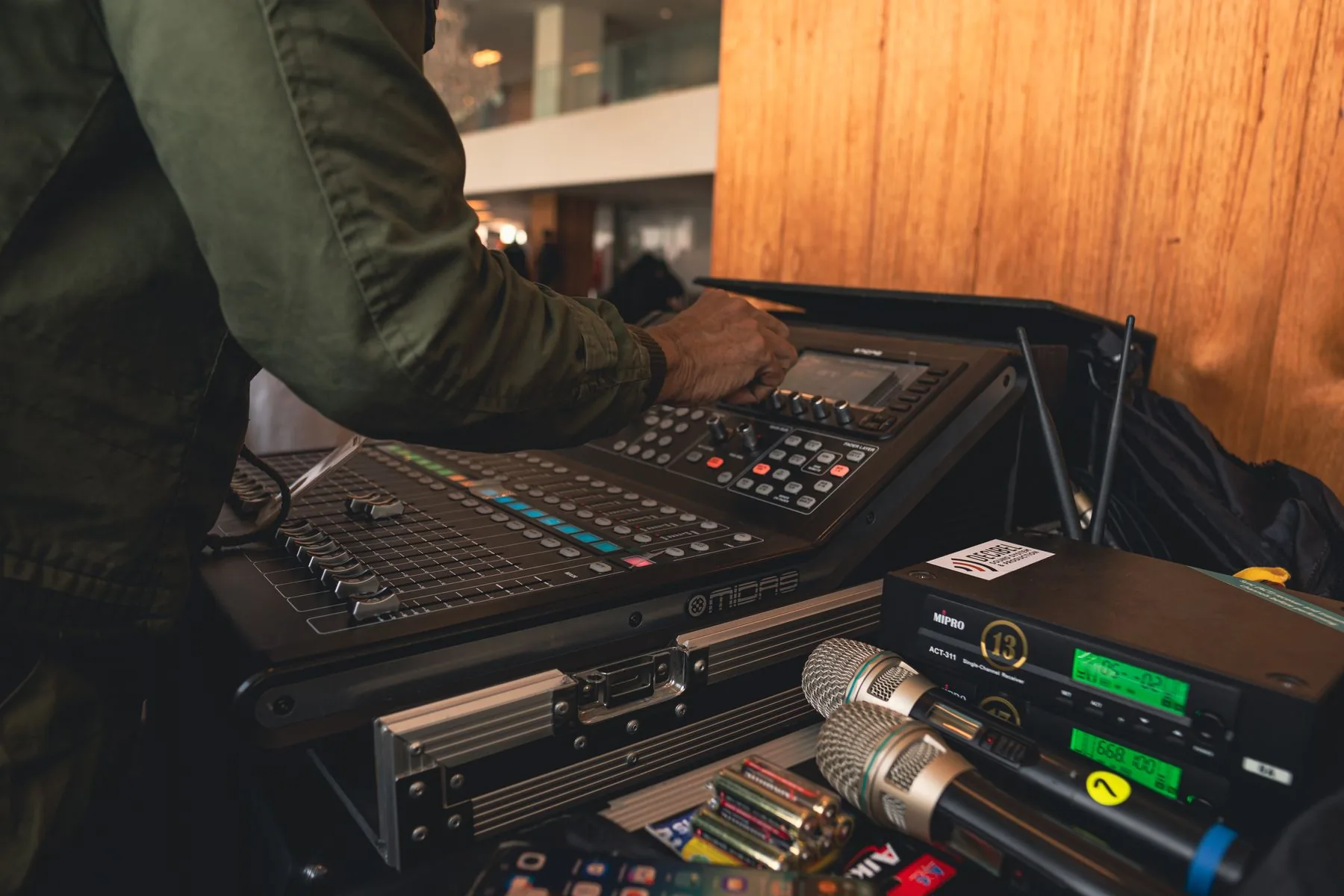 A sound technician adjusts the controls of a digital audio mixer.