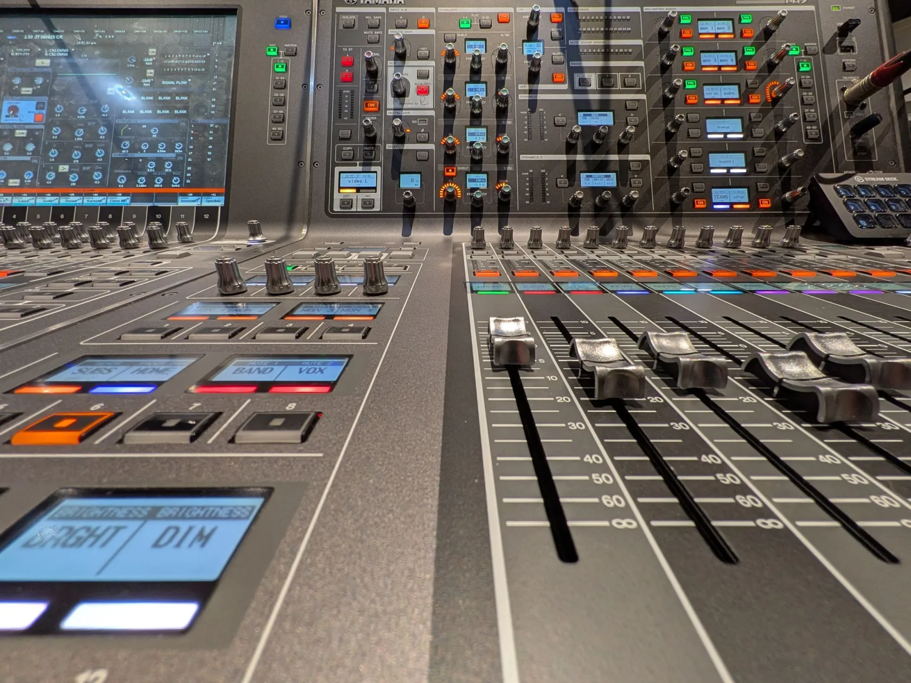 Close view of faders and controls on a professional audio mixing console.